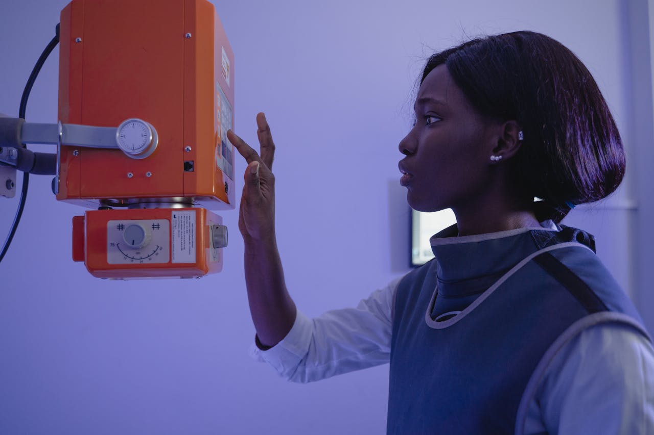 service-05 African American female healthcare worker using X-ray equipment in a clinical setting.
