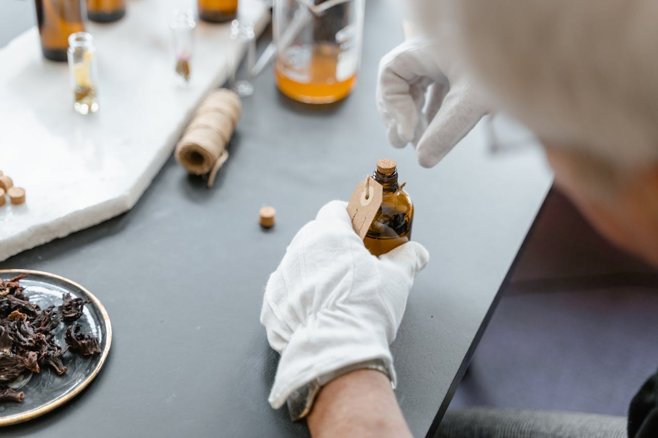 service-03 Person in gloves carefully handling aromatic compound in laboratory setting with various ingredients.