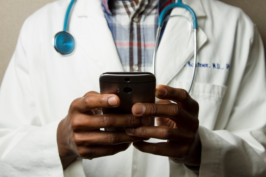 service-01 Doctor Holding Cell Phone. Cell phones and other kinds of mobile devices and communications technologies are of increasing importance in the delivery of health care. Photographer Daniel Sone